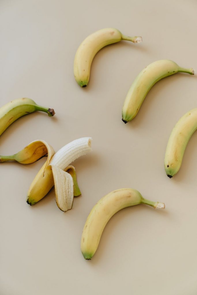 yellow banana fruit on white surface