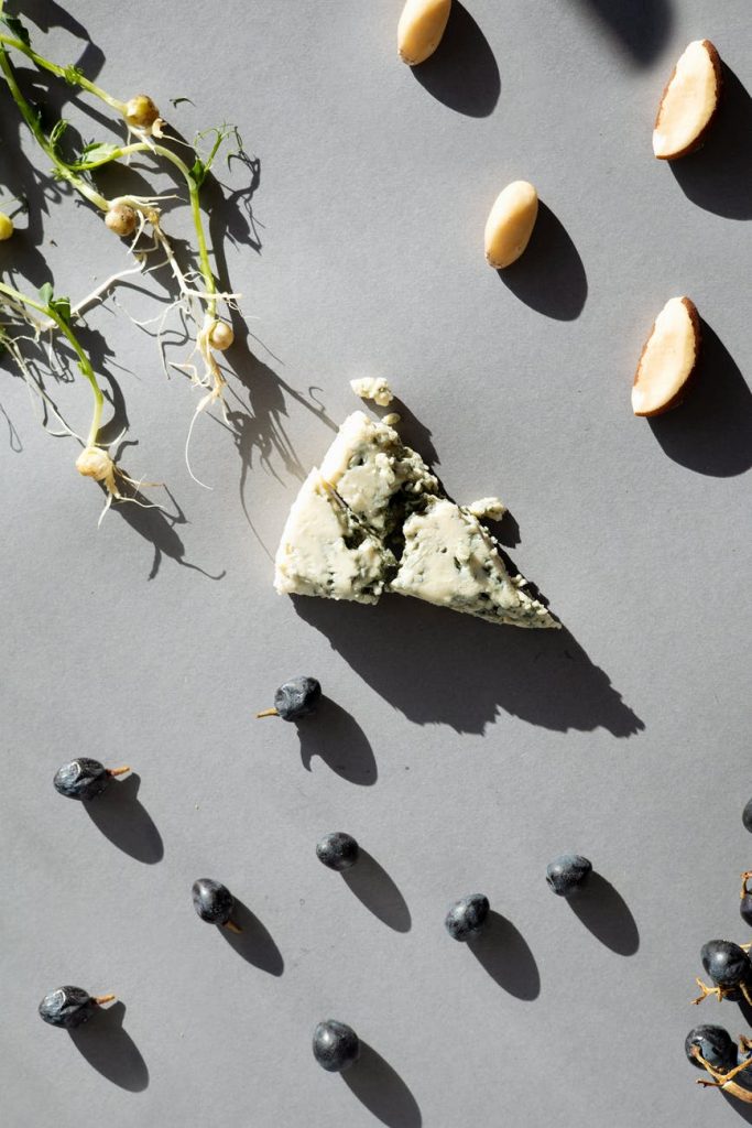 a piece of cheese with fruits and nuts